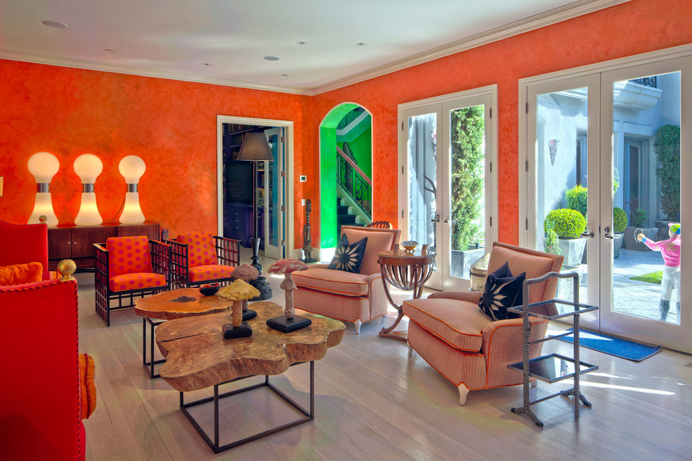 Immagine di un grande soggiorno eclettico chiuso con sala formale, pareti arancioni, parquet chiaro, pavimento marrone, camino classico e cornice del camino piastrellata
