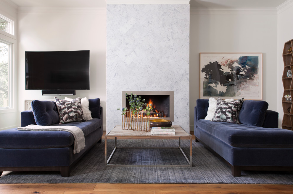 Foto de salón clásico renovado con marco de chimenea de metal, televisor colgado en la pared, paredes blancas, suelo de madera en tonos medios y todas las chimeneas