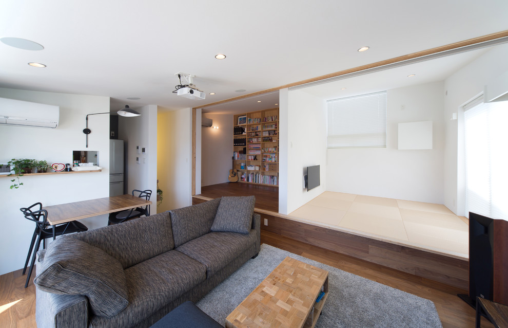 Kleines, Repräsentatives, Offenes Modernes Wohnzimmer mit weißer Wandfarbe und dunklem Holzboden in Sonstige