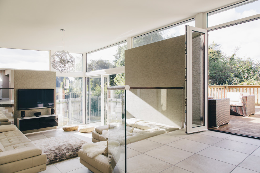 Offenes Modernes Wohnzimmer mit beiger Wandfarbe und TV-Wand in Sonstige