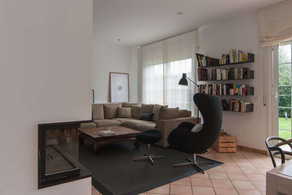 Modelo de salón para visitas abierto moderno grande sin chimenea con paredes blancas, suelo de baldosas de terracota y pared multimedia