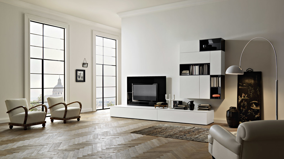 Imagen de biblioteca en casa abierta minimalista grande sin chimenea con paredes blancas, suelo de madera clara y televisor colgado en la pared