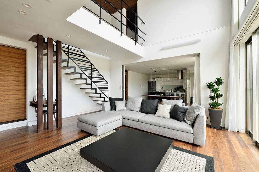 Inspiration pour un salon minimaliste ouvert avec un mur blanc, parquet foncé et un sol marron.