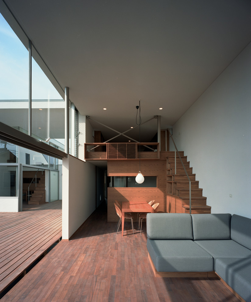 Offenes, Mittelgroßes Modernes Wohnzimmer ohne Kamin mit weißer Wandfarbe, dunklem Holzboden, braunem Boden, verputzter Kaminumrandung und freistehendem TV in Tokio