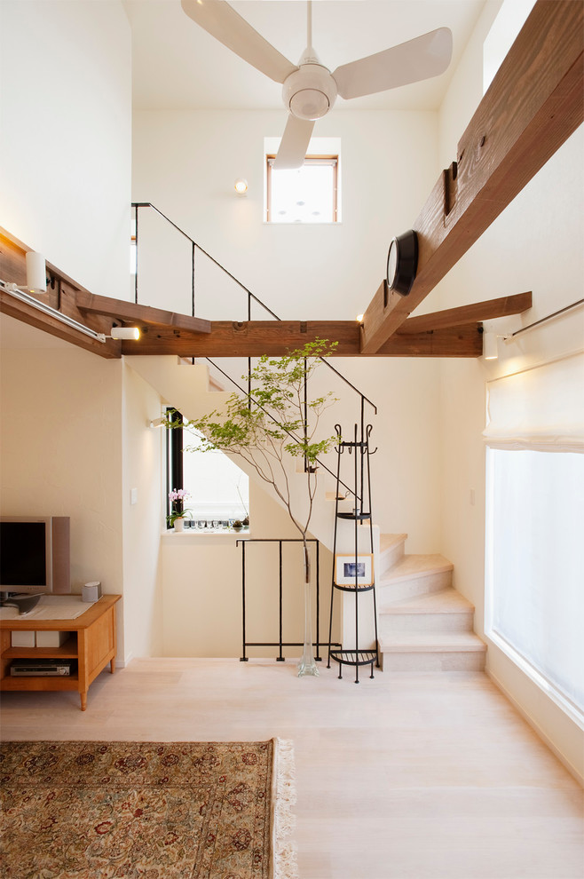 Modernes Wohnzimmer mit weißer Wandfarbe, freistehendem TV und beigem Boden in Tokio