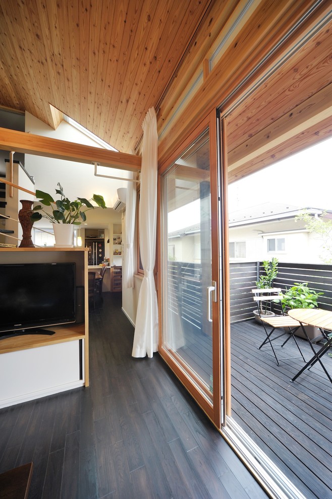 Immagine di un soggiorno design di medie dimensioni e chiuso con pareti bianche, parquet scuro, TV autoportante, pavimento marrone e stufa a legna