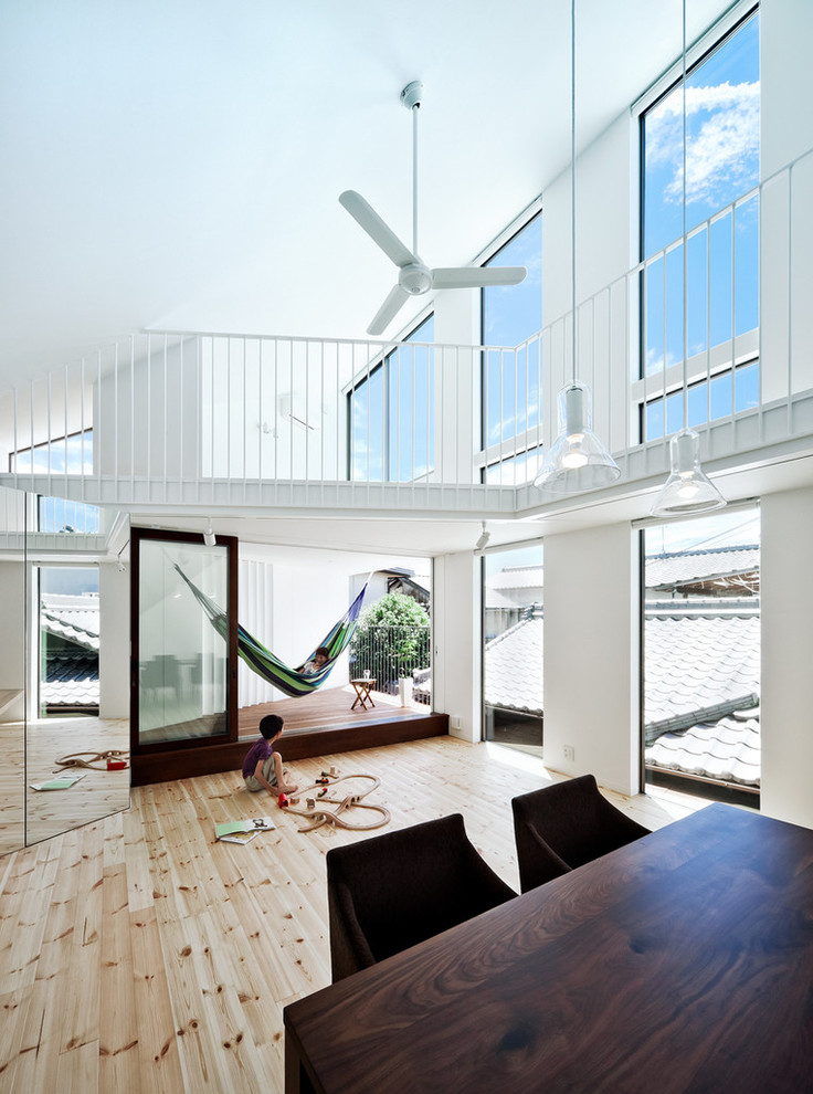 На фото: гостиная комната в современном стиле с белыми стенами и светлым паркетным полом с