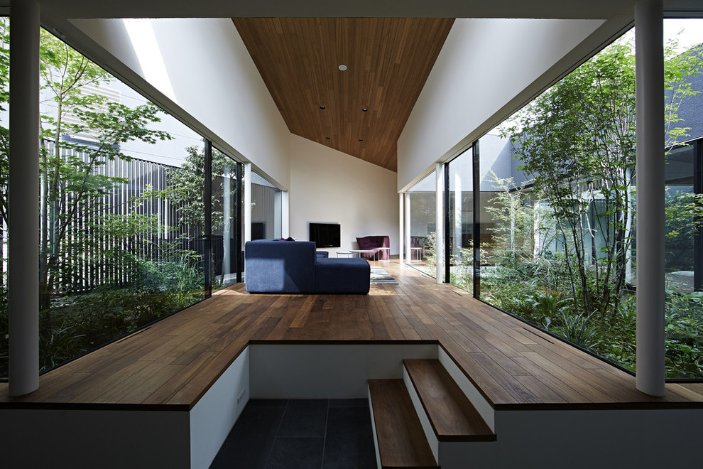 Idee per un soggiorno minimalista con pareti bianche, parquet scuro, nessun camino, TV a parete e pavimento marrone