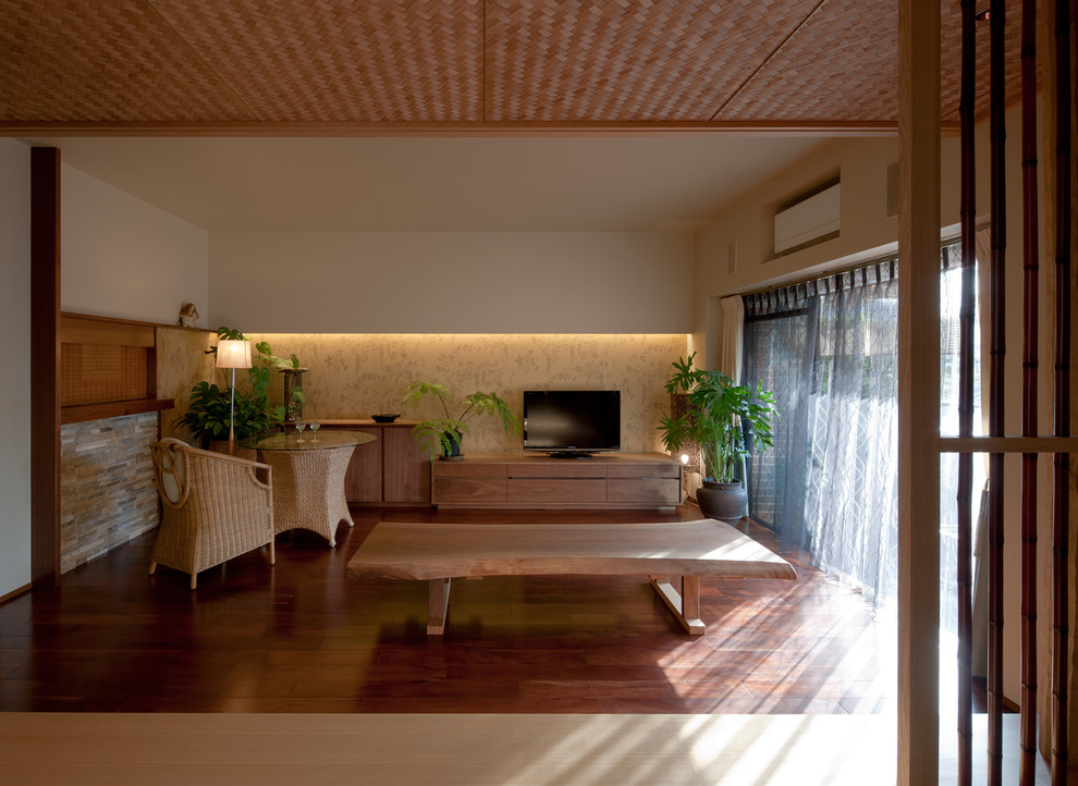 Стильный дизайн: гостиная комната в восточном стиле с белыми стенами, темным паркетным полом и отдельно стоящим телевизором - последний тренд