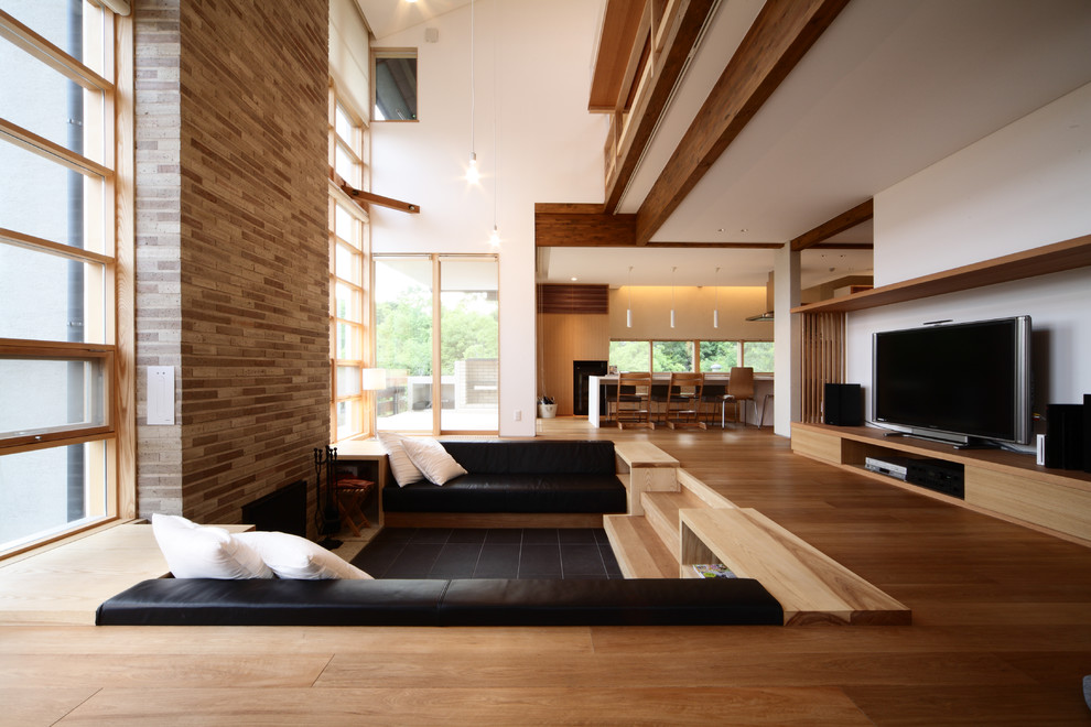 Cette image montre un salon minimaliste avec un mur blanc, un sol en bois brun, une cheminée standard et un téléviseur indépendant.