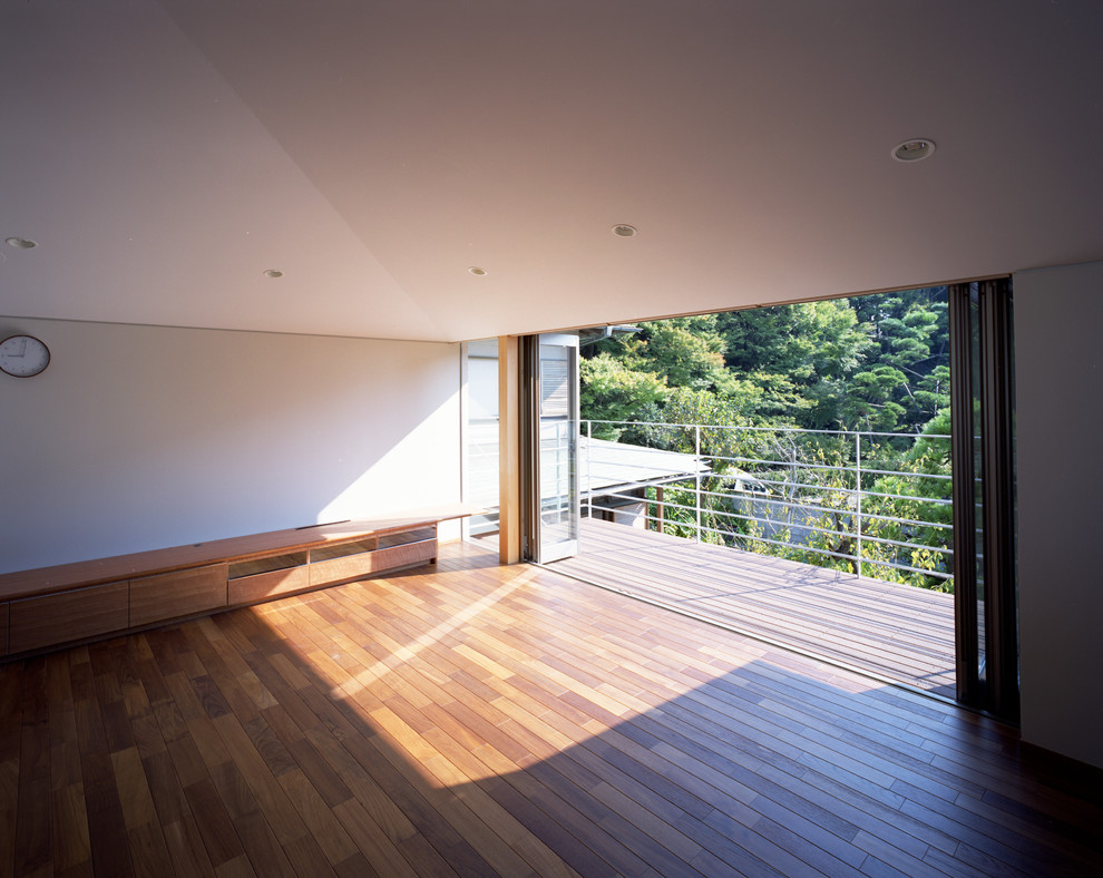 Foto di un soggiorno minimalista di medie dimensioni e aperto con pareti bianche, pavimento in legno massello medio, nessun camino, TV autoportante e pavimento marrone
