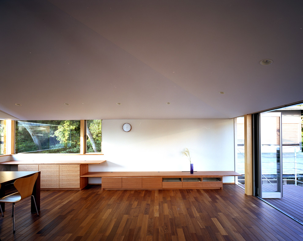 Idée de décoration pour un salon minimaliste de taille moyenne et ouvert avec un mur blanc, un sol en bois brun, aucune cheminée, un téléviseur indépendant et un sol marron.