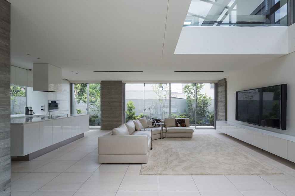 Cette image montre un grand salon minimaliste ouvert avec un mur blanc, un sol en marbre, un téléviseur fixé au mur et un sol blanc.