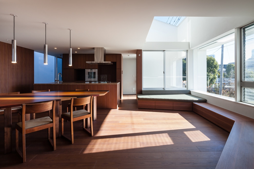 Cette image montre un salon minimaliste de taille moyenne et ouvert avec un sol en contreplaqué, un téléviseur fixé au mur et un sol marron.
