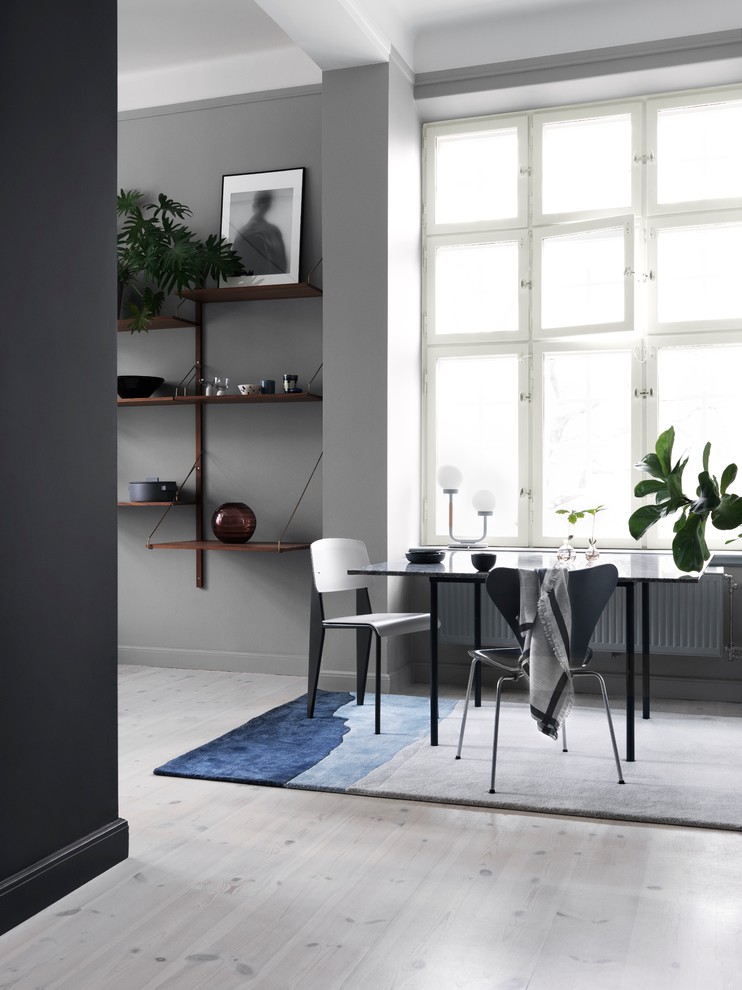 Стильный дизайн: гостиная-столовая в скандинавском стиле с серыми стенами и деревянным полом - последний тренд