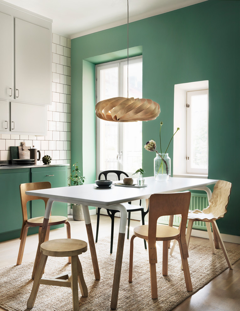 Immagine di una sala da pranzo aperta verso la cucina minimal con pareti verdi