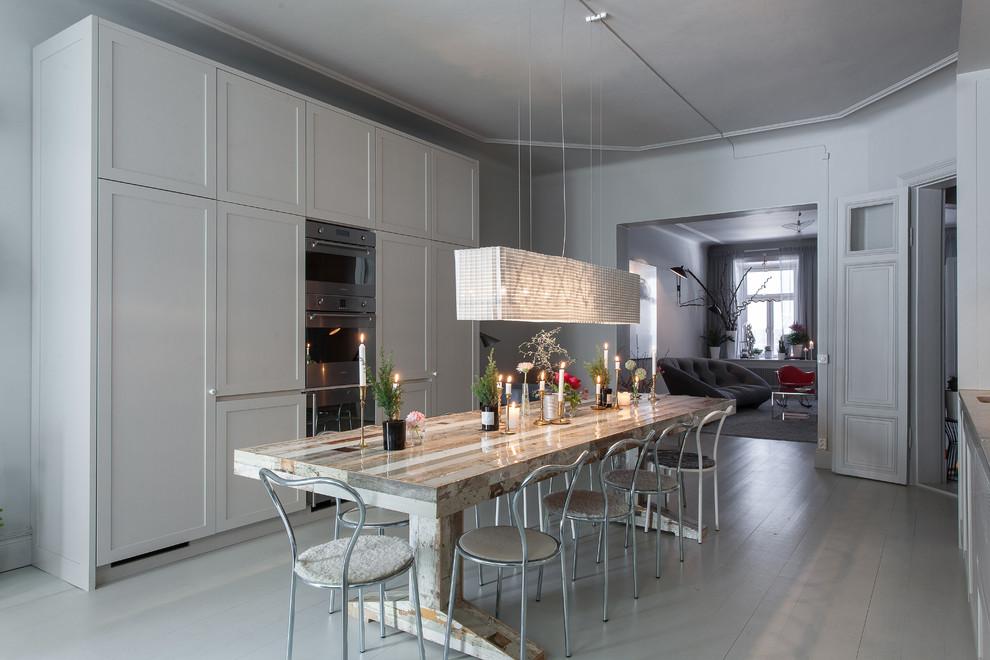 Réalisation d'une grande salle à manger ouverte sur la cuisine tradition avec un mur gris, parquet peint et aucune cheminée.