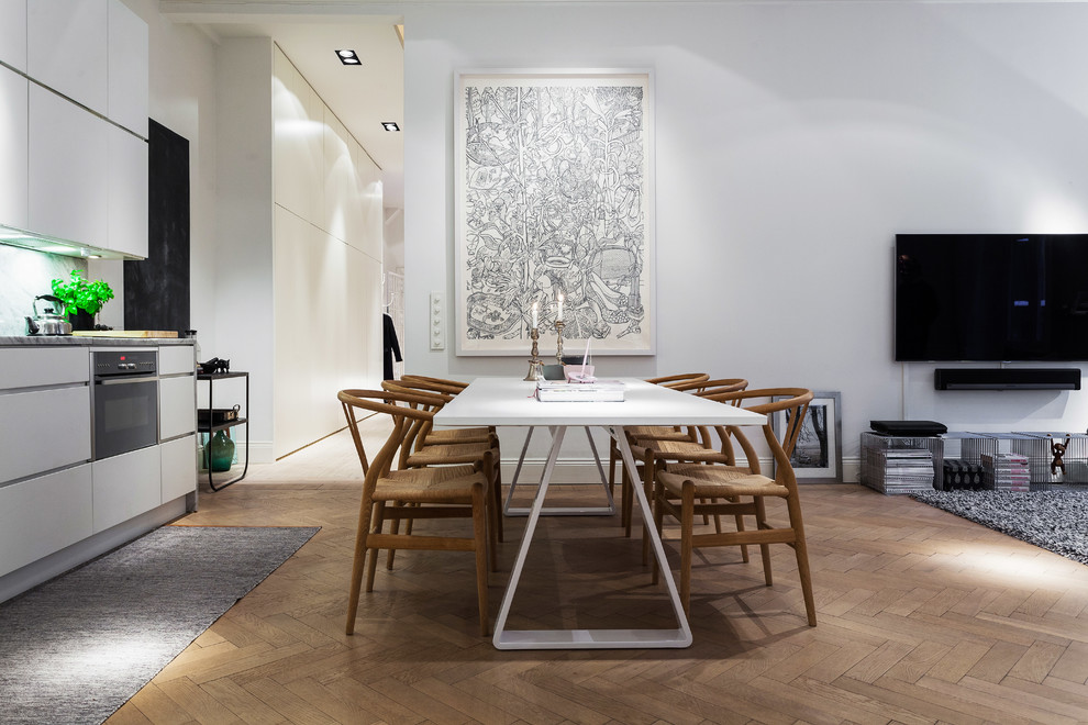 Inspiration pour une salle à manger ouverte sur la cuisine nordique de taille moyenne avec un mur blanc, un sol en bois brun et aucune cheminée.