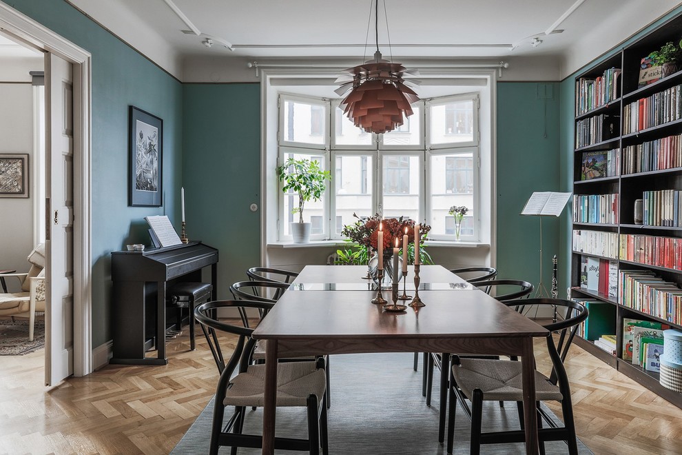 Nordisk inredning av en separat matplats, med gröna väggar, ljust trägolv och beiget golv