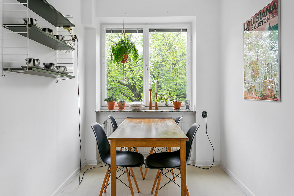 Nordisk inredning av ett kök med matplats, med vita väggar och beiget golv
