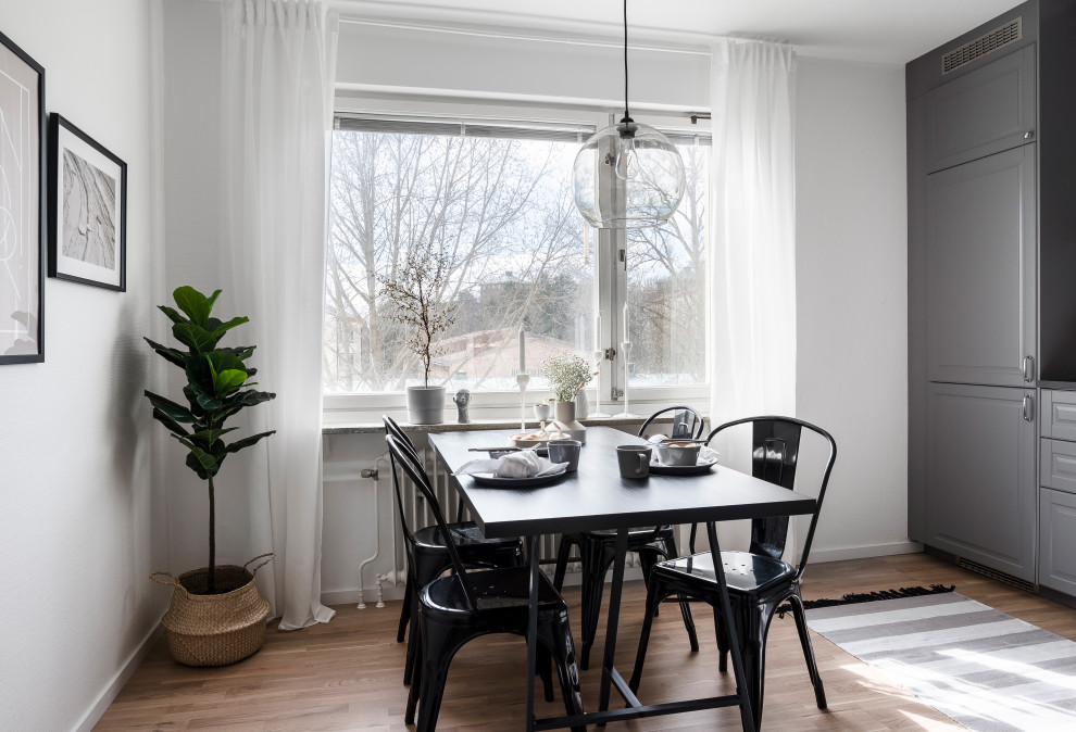 Exempel på ett mellanstort minimalistiskt kök med matplats, med vita väggar, mellanmörkt trägolv och brunt golv