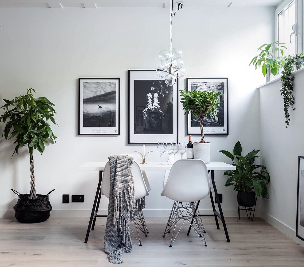 Inspiration for a medium sized scandinavian enclosed dining room in Stockholm with white walls and light hardwood flooring.