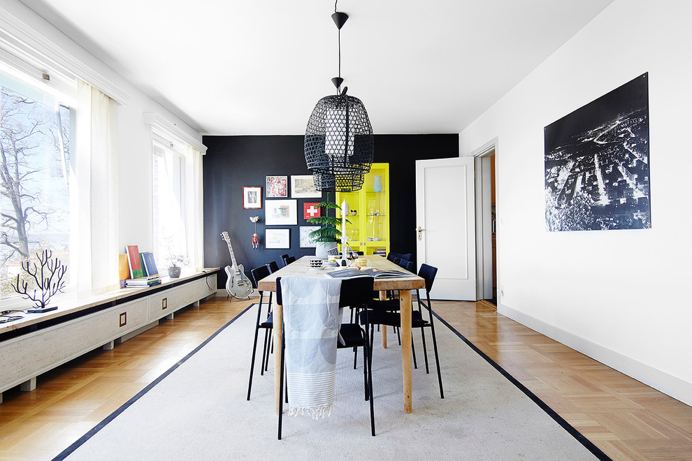 Geschlossenes, Mittelgroßes Modernes Esszimmer ohne Kamin mit schwarzer Wandfarbe und hellem Holzboden in Göteborg