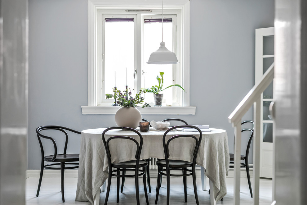 Réalisation d'une salle à manger nordique avec un mur gris, parquet clair et un sol beige.