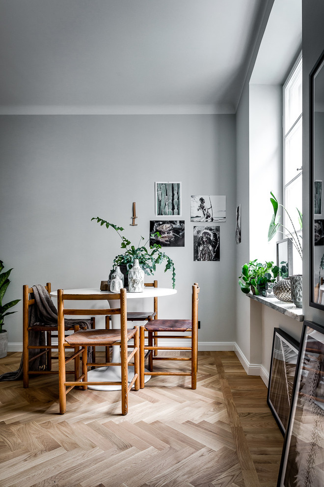 Exemple d'une salle à manger scandinave fermée et de taille moyenne avec un mur gris et parquet clair.