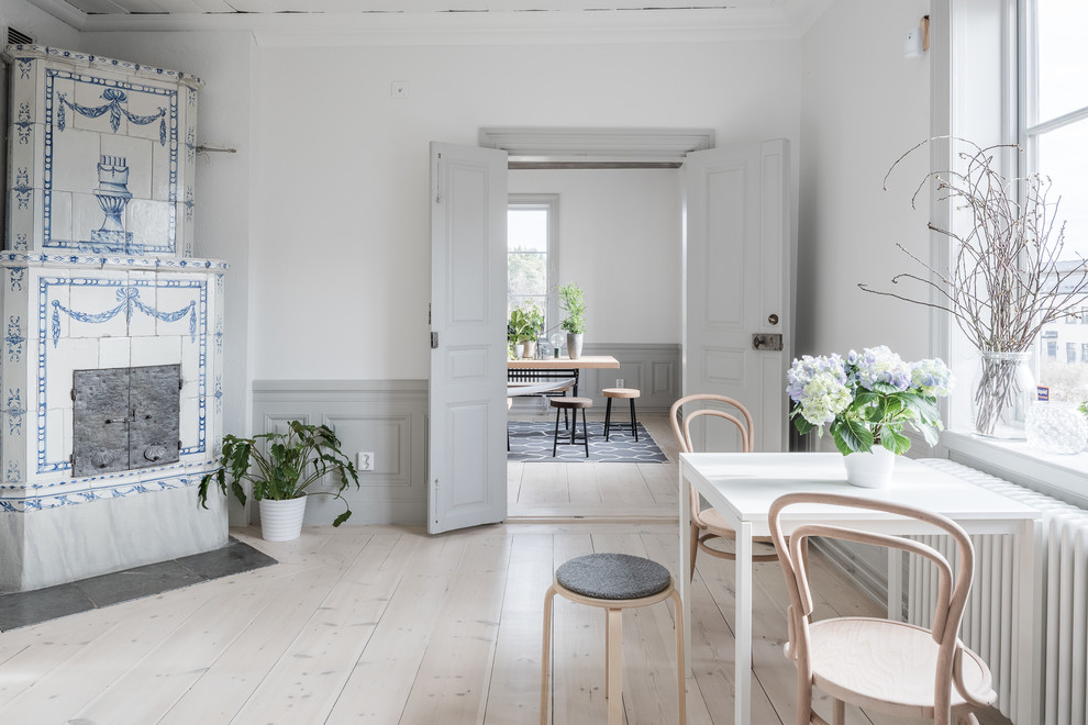 Inspiration for a medium sized scandi dining room in Stockholm with white walls, light hardwood flooring and no fireplace.