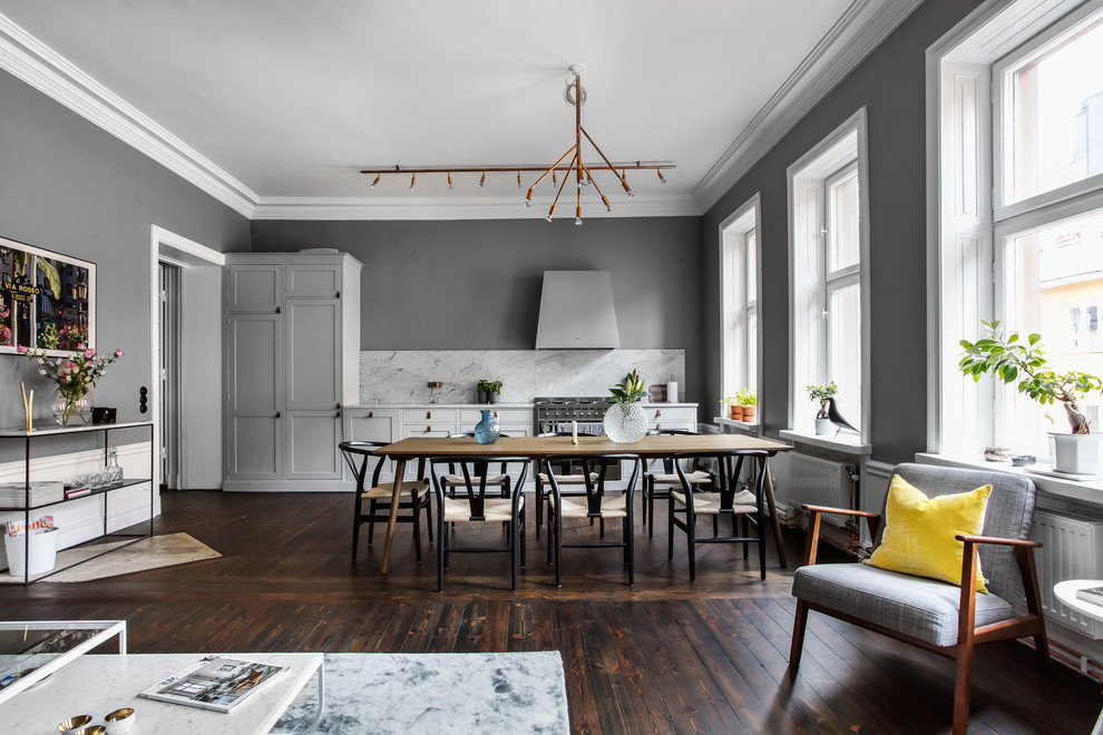Large scandinavian open plan dining room in Stockholm with grey walls, dark hardwood flooring and brown floors.
