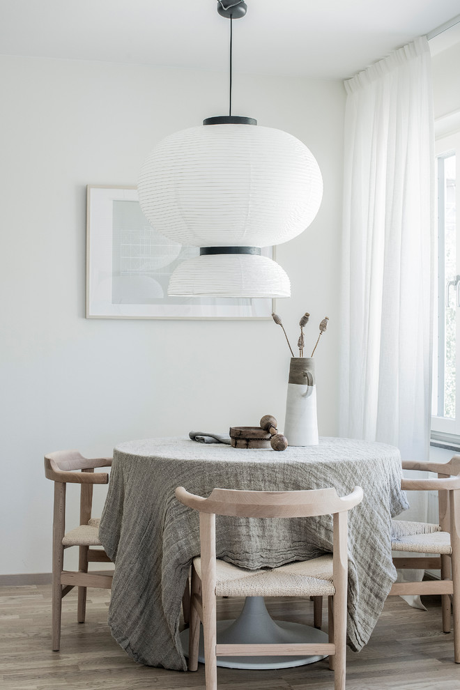 Design ideas for a small scandi enclosed dining room in Stockholm with white walls, light hardwood flooring and beige floors.
