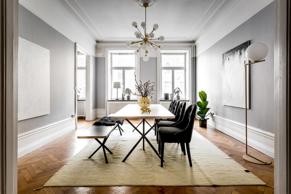 Idée de décoration pour une salle à manger ouverte sur le salon nordique de taille moyenne avec un mur gris et un sol en bois brun.