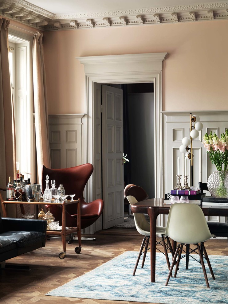 На фото: гостиная-столовая среднего размера в стиле фьюжн с розовыми стенами и паркетным полом среднего тона без камина с