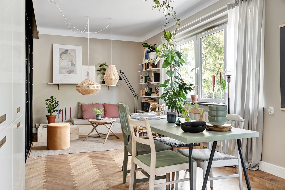 Idées déco pour une petite salle à manger ouverte sur le salon scandinave avec un mur beige, un sol en bois brun, un sol beige et éclairage.