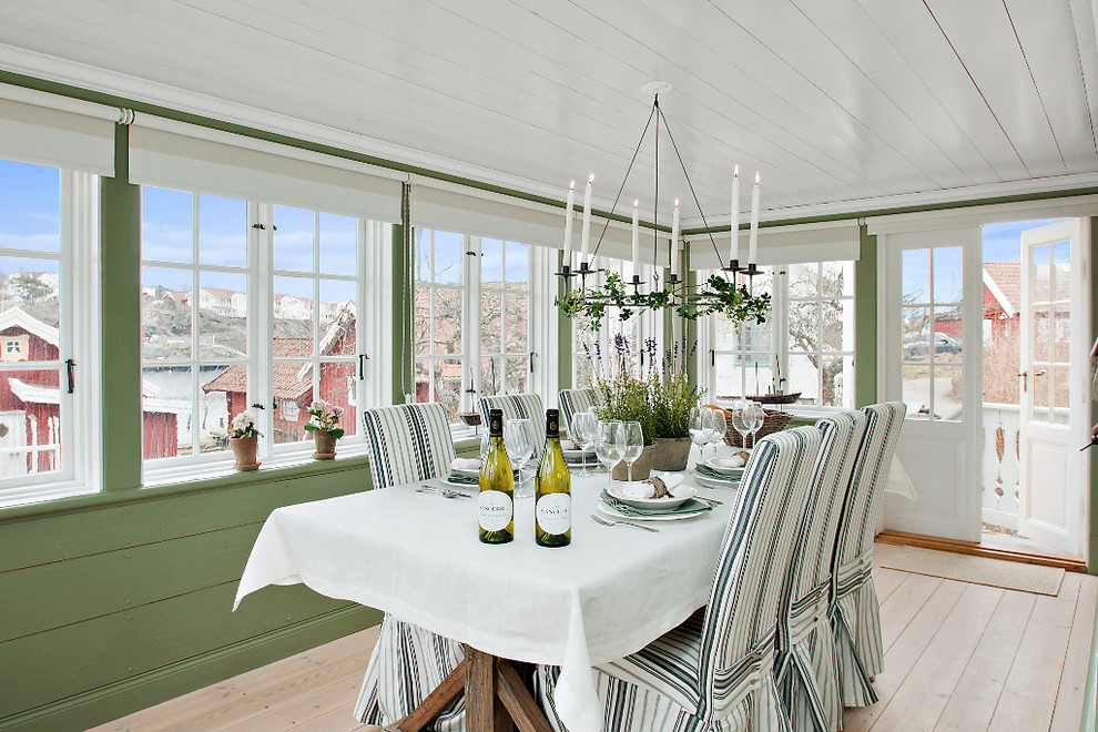 Cette image montre une salle à manger ouverte sur le salon rustique de taille moyenne avec un mur vert, parquet clair et aucune cheminée.