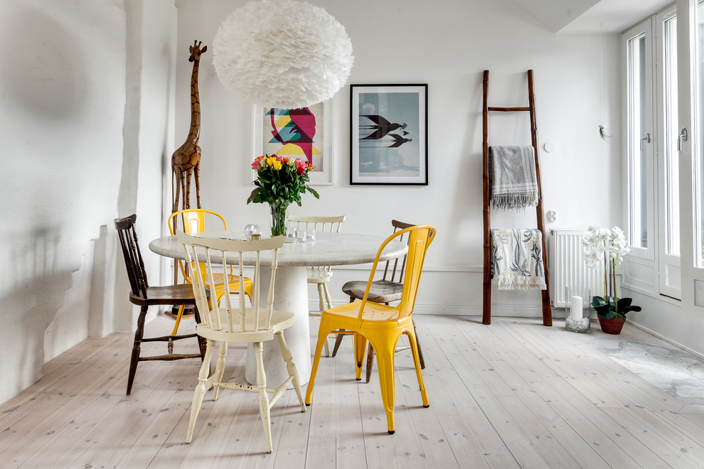 Aménagement d'une salle à manger scandinave avec un mur blanc et parquet clair.