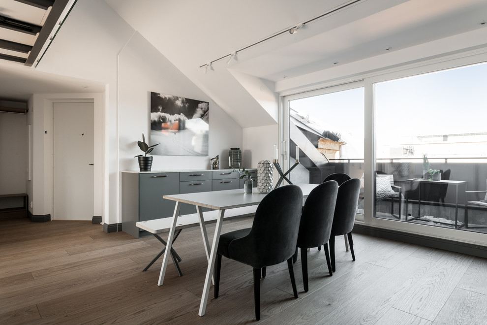 Design ideas for a scandinavian dining room in Stockholm with white walls and brown floors.