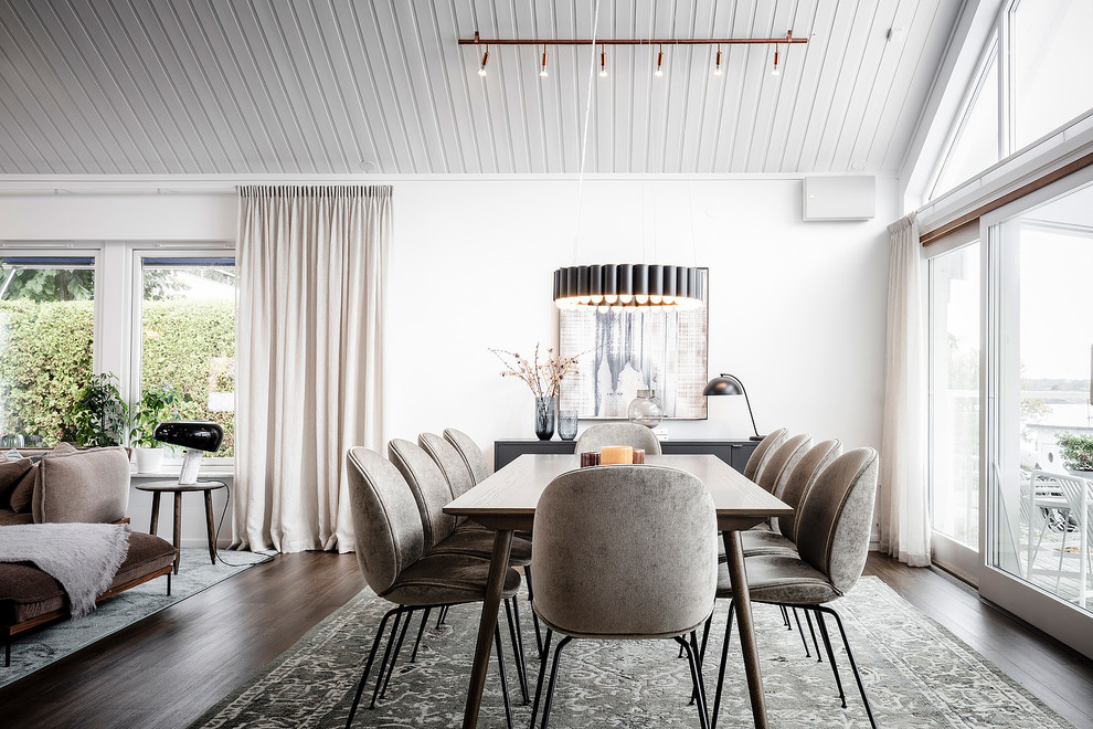 Photo of a scandi dining room in Gothenburg with white walls, dark hardwood flooring and brown floors.