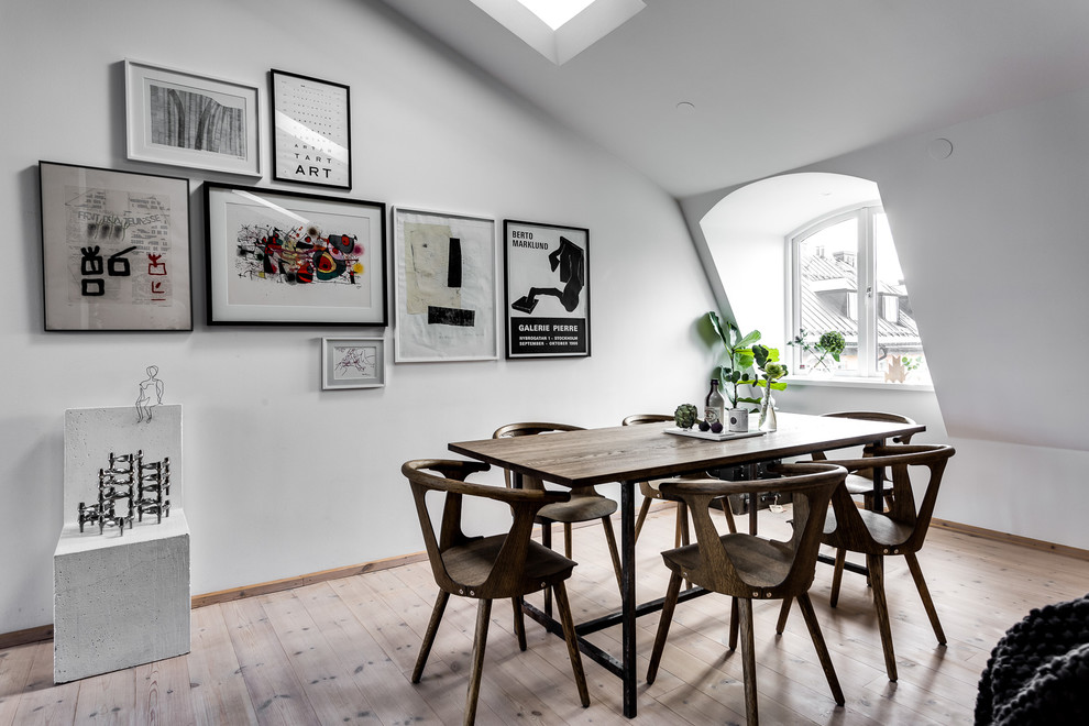 Inspiration för en stor minimalistisk matplats, med vita väggar och ljust trägolv