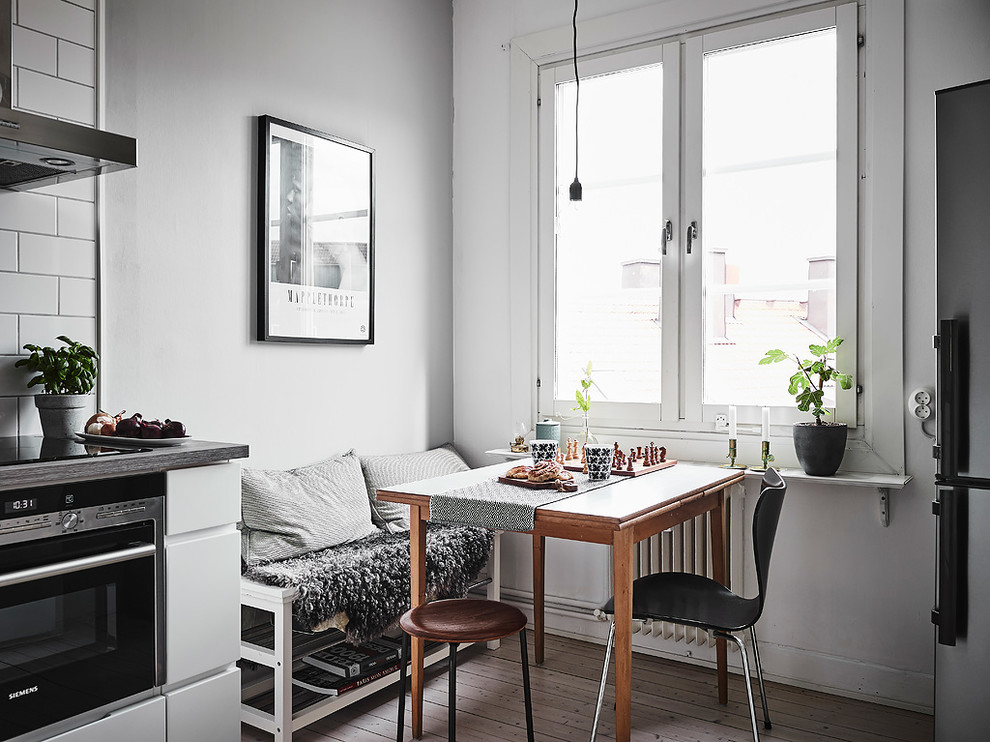 Inspiration för ett minimalistiskt kök med matplats, med vita väggar, ljust trägolv och beiget golv