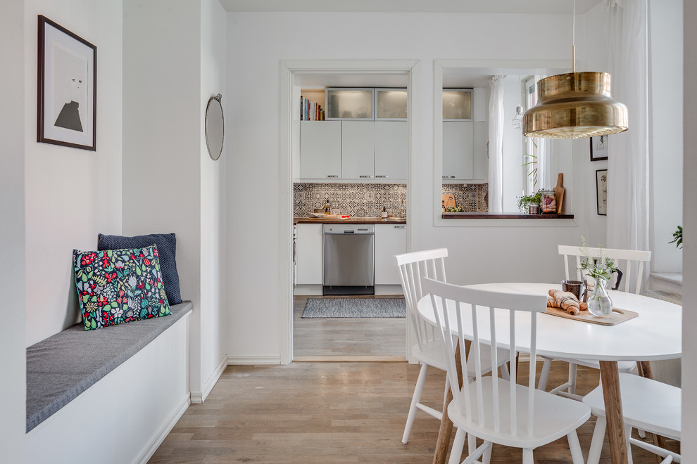 Imagen de comedor de cocina escandinavo de tamaño medio con paredes blancas y suelo de madera clara