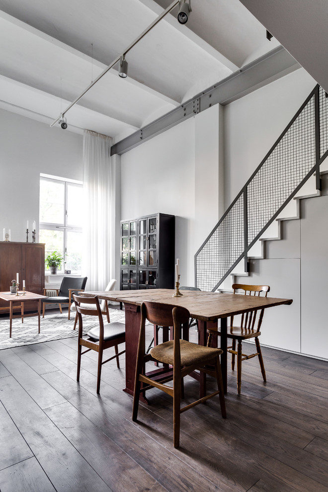 Photo of a large scandi open plan dining room in Stockholm with white walls and dark hardwood flooring.