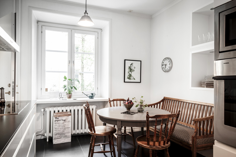Inredning av ett minimalistiskt litet kök med matplats, med vita väggar