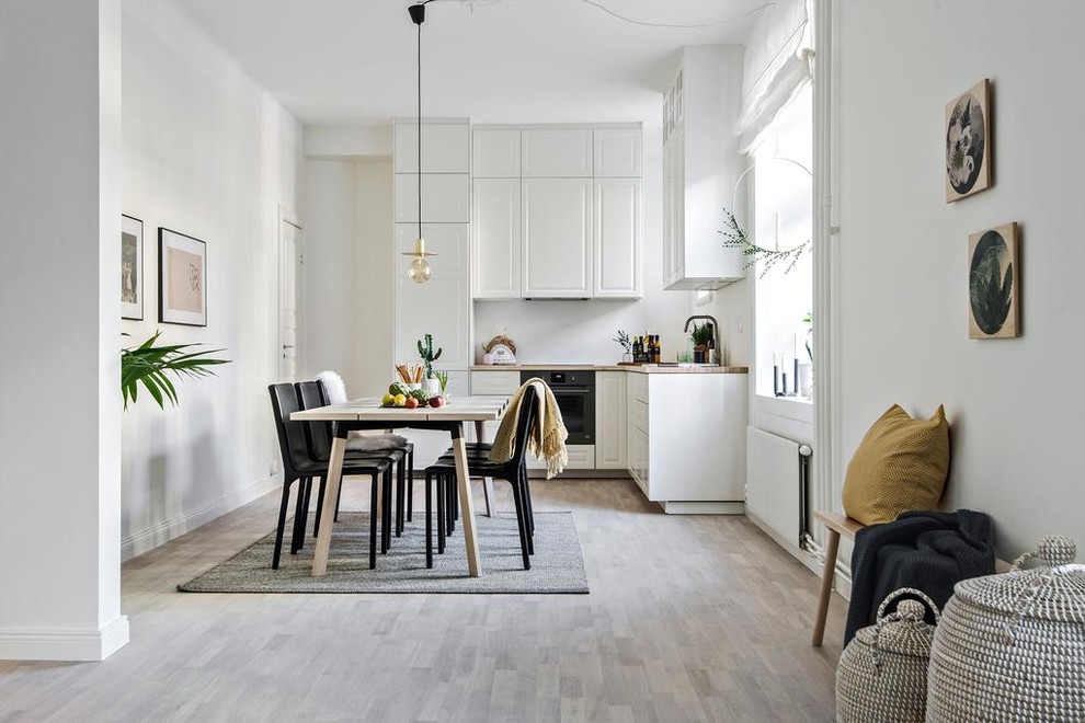 Esempio di una sala da pranzo aperta verso il soggiorno scandinava di medie dimensioni con pareti bianche e pavimento grigio