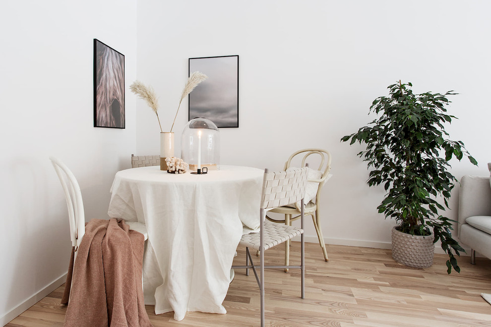 Cette photo montre une salle à manger scandinave avec un mur blanc, parquet clair et un sol beige.