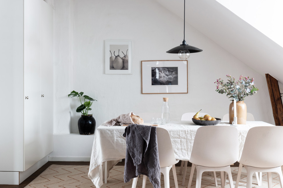 This is an example of a medium sized scandinavian kitchen/dining room in Stockholm with white walls and brown floors.