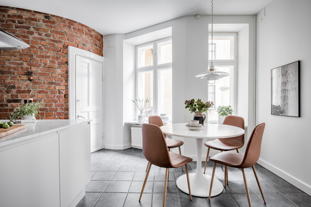 Idées déco pour une salle à manger ouverte sur la cuisine scandinave de taille moyenne avec un mur blanc et un sol gris.