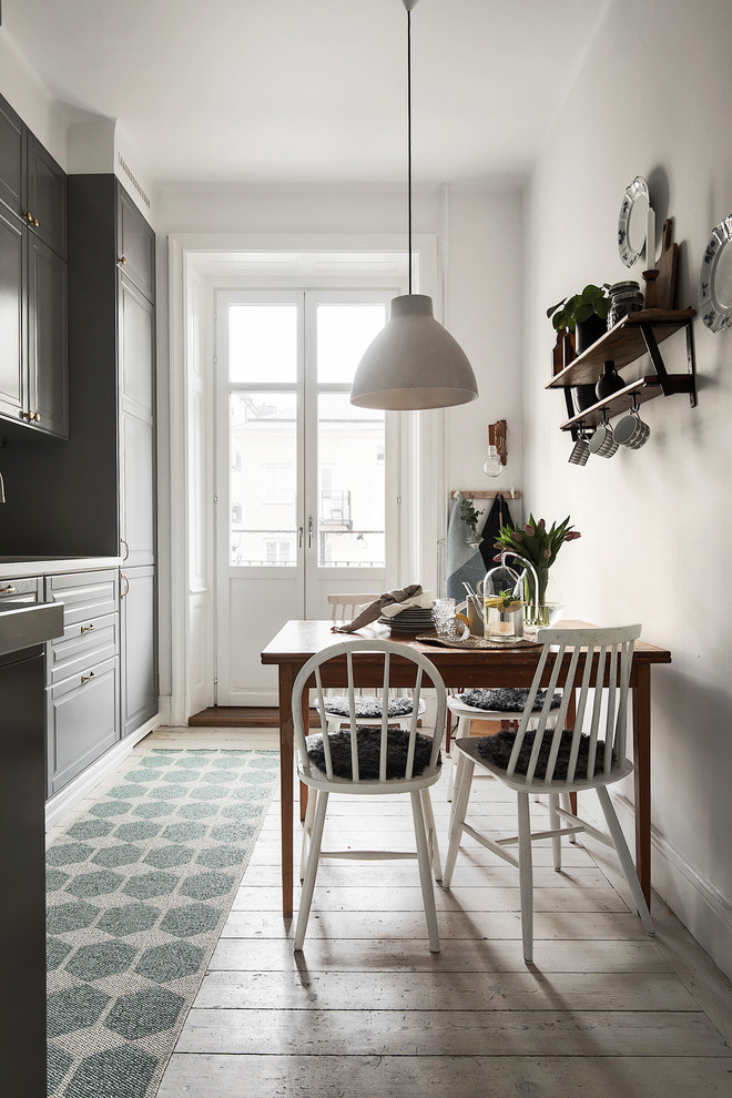 Aménagement d'une petite salle à manger ouverte sur la cuisine scandinave avec un mur blanc, parquet clair et un sol beige.