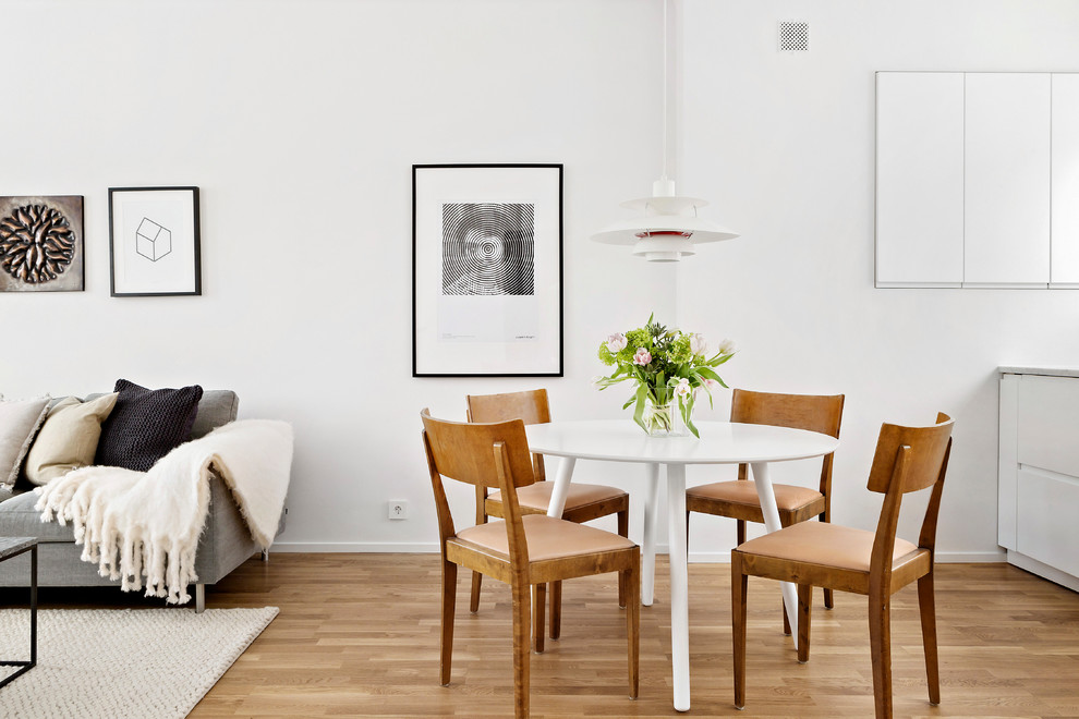 Immagine di una sala da pranzo scandinava di medie dimensioni con pareti bianche e pavimento in legno massello medio